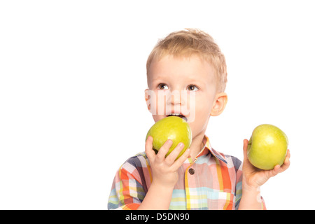 Beautiful happy smiling joyful child (little boy) eating healthy food (green apples) isolated on white background. Stock Photo