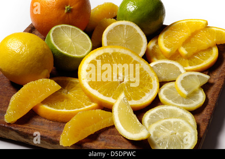 Selection of fresh citrus fruit on chopping board Stock Photo