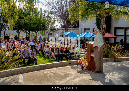 The principal of a Southern California continuation high school speaks before an audience on graduation day. Stock Photo