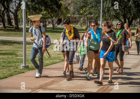 Multiethnic college students in Hawaiian hats and leis walk through the campus of the University of California at Riverside. Stock Photo
