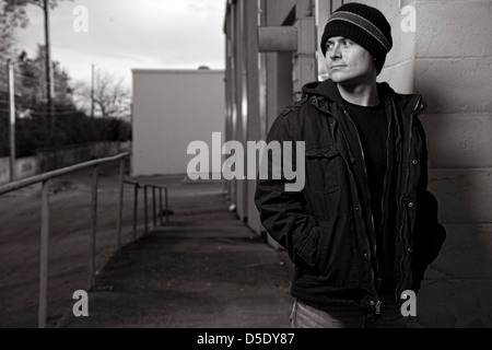 Man in hat outside in alley Stock Photo