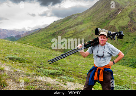Portrait of professional photographer with large telephoto lens & tripod, Denali National Park, Alaska, AK Stock Photo