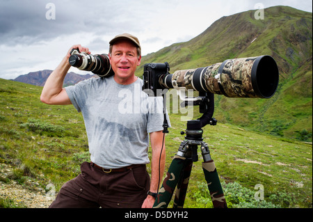 Portrait of professional photographer with large telephoto lens & tripod, Denali National Park, Alaska, AK Stock Photo