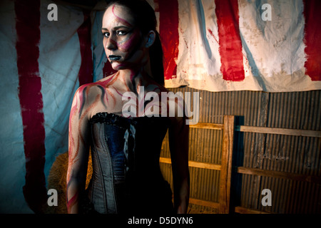 Woman with tattoos corset standing in tented alley Stock Photo