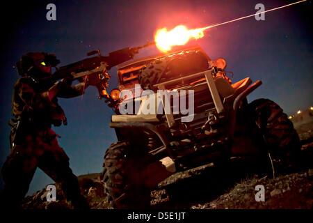 A US Marine Special Operations Team member fires a M240B machine gun during night fire sustainment training March 28, 2013 in Helmand province, Afghanistan. Marine Special Operations Team members are deployed in Helmand province to train and mentor Afghan National Security Forces. Stock Photo