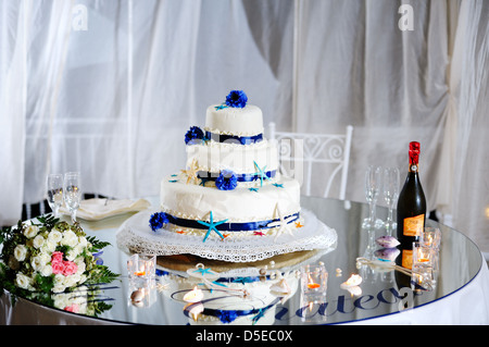 beatiful decorated wedding cake with bride's bouquet, stemware and champagne Stock Photo