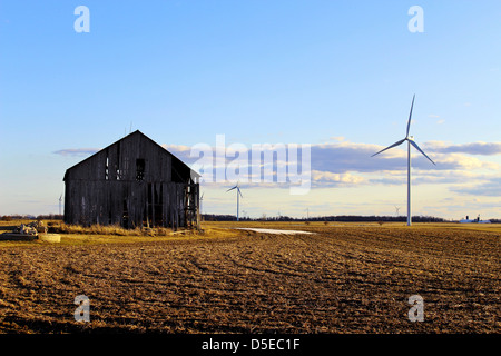 Wind turbines with barn and fields in the foreground. Stock Photo