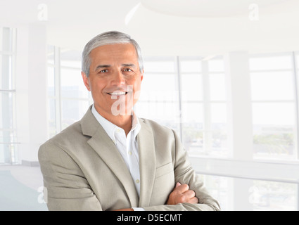 Closeup of a casual businessman in a modern office with his arms folded. Horizontal Format. Stock Photo