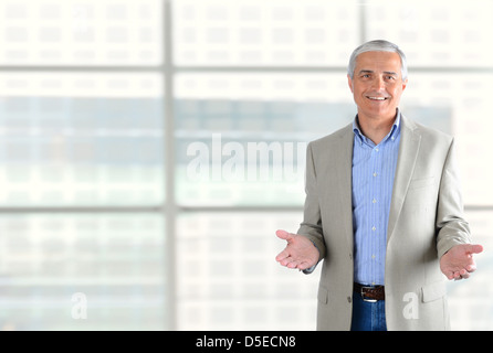 Closeup of a smiling middle aged businessman gesturing with both hand. Stock Photo