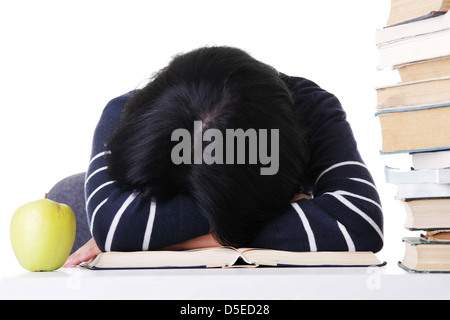Young woman sleeping on desk next to pile of books, isolated on white  Stock Photo