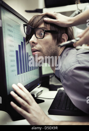 Office worker forced to work harder and harder Stock Photo