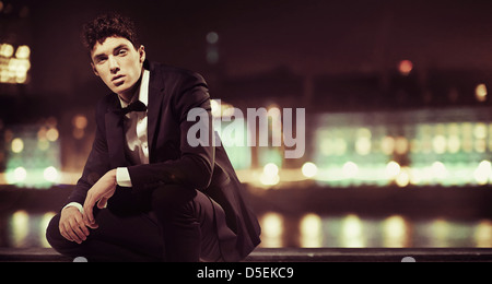 Stylish young man with night town over the background Stock Photo