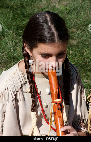 Native American Indian girl playing a wooden flute Stock Photo
