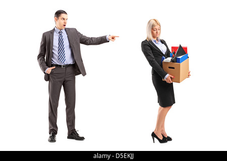 Full length portrait of an angry boss firing a woman with a box of her personal items isolated on white background Stock Photo