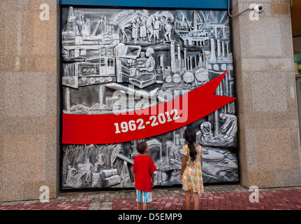 2 children view decorations celebrating The 50th Anniversary of Independence at Parliament building Wrightson Road,Port of Spain Stock Photo