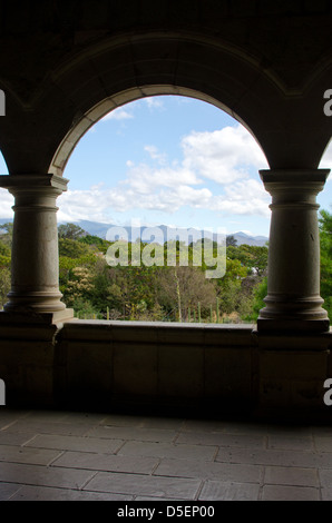 Looking through an arch in the Centro Cultural Santo Domingo over the Jardín Etnobotánico to the distant mountains. Stock Photo