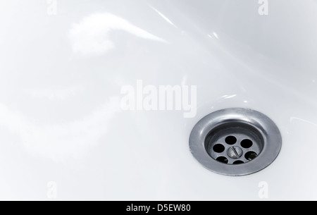 Standard round drain hole in white domestic sink Stock Photo