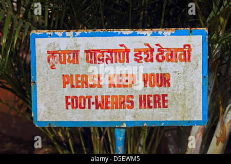 A noticeboard indicating Please Keep Your Foot Wears Here Stock Photo