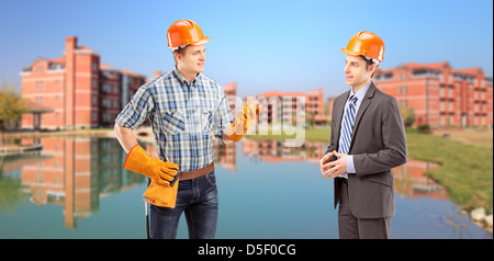 Male manual worker having a conversation with architect, buildings in the background Stock Photo