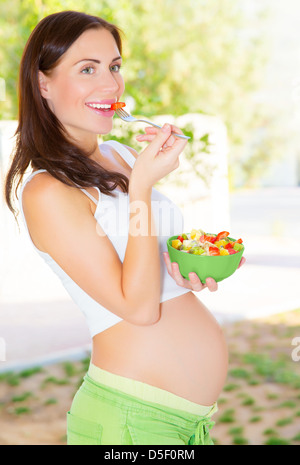 Cute pregnant girl having breakfast on the kitchen at home, happy motherhood, healthy pregnancy concept Stock Photo