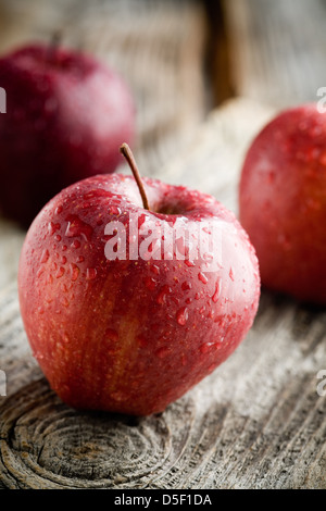 Three red apples on wooden table, selective focus Stock Photo