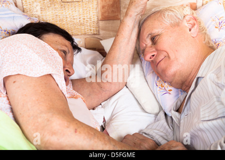 Detail of senior couple relaxing in bed. Stock Photo