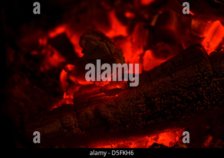 Embers glowing red and black in a fire. Stock Photo