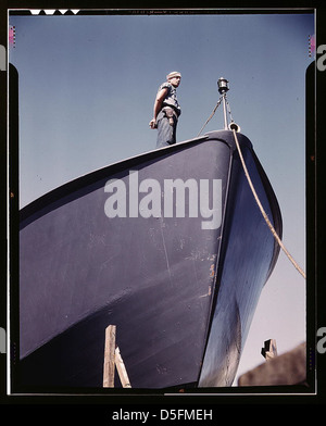 A Coast Guard sentry stands watch over a new torpedo boat under construction at a southern shipyard. In addition to wooden torpedo boats, the yard also turns out many steel boats for the Navy. Higgins Industries, Inc., New Orleans, La. (LOC) Stock Photo