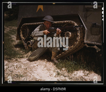 A young soldier of the armored forces holds and sights his Garand rifle like an old timer, Fort Knox, Ky. He likes the piece for its fine firing qualities and its rugged, dependable mechanism. Infantryman with halftrack (LOC) Stock Photo