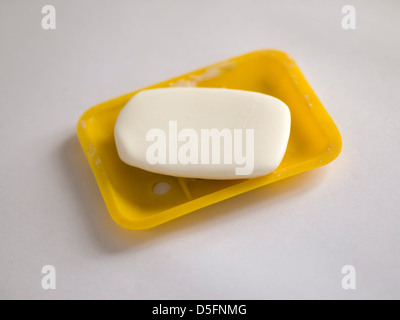 Bar of soap on yellow plastic holder Stock Photo