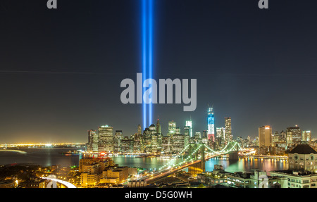 Panorama of Brooklyn Bridge and downtown Manhattan at night with Twin Towers Memorial shooting to the sky. Stock Photo