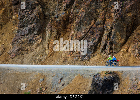 Two female tourists ride bicycles on the limited access Denali Park Road, Denali National Park, Alaska, USA Stock Photo