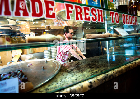 New York style pizza restaurant with man making pizza behind glass counter Stock Photo