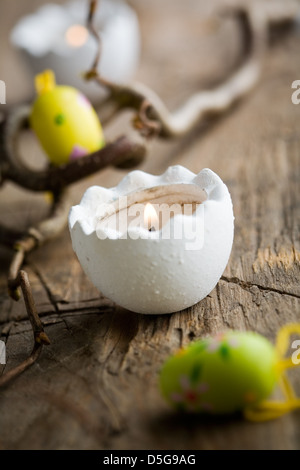 Easter candles on wooden table with egg decorations Stock Photo