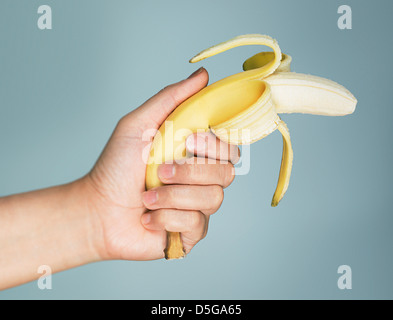 A banana is pointed like a gun with its end peeled back in a comedic fashion Stock Photo