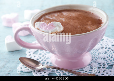 Hot chocolate and a heart shaped marsmallow in a vintage pink cup Stock Photo