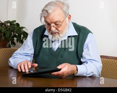 Senior man using his digital tablet Stock Photo