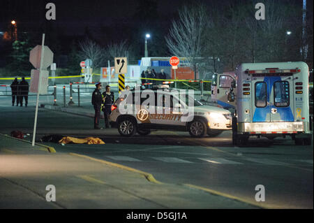 The body of a shooting victim remained in the parking lot while forensic investigators gathered evidence. A woman has been rushed to Sunnybrook Hospital, and another declared dead on the scene, after a shooting at Yorkdale Shopping centre in Toronto. Stock Photo