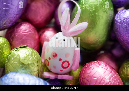 Easter bunny in the middle of chocolate eggs, selective focus Stock Photo