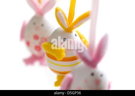 Easter bunnies hanging on white background, selective focus Stock Photo