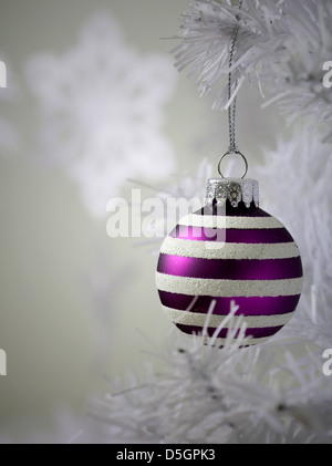 Colourful christmas baubles hanging from white christmas tree Stock Photo