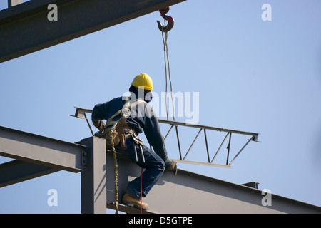 Ironworker connecting steel beams during construction of a building ...