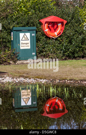 Danger deep water sign and life ring next to water Stock Photo