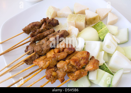 Mutton and Chicken Satay with Chopped Cucumbers Onions and Ketupat Rice Cake Stock Photo