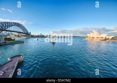 Ferries pass between the majestic Sydney Opera House and the Sydney Harbour Bridge. Stock Photo