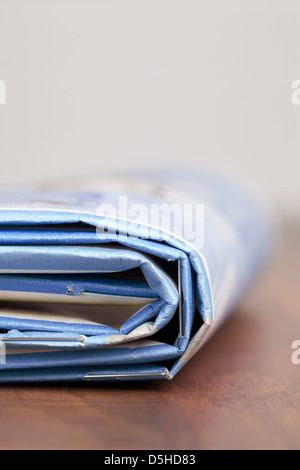 Folded newspapers on brown wooden table Stock Photo