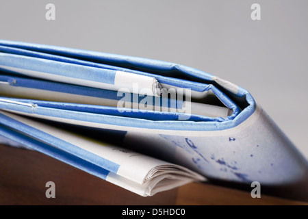 Folded newspapers on brown wooden table Stock Photo