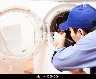 Technician repairing a washing machine Stock Photo
