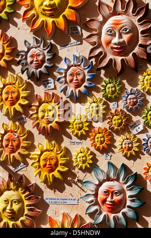 Ornamental sun face wall plaques for sale at a ceramics shop in Collioure, southern France. Stock Photo