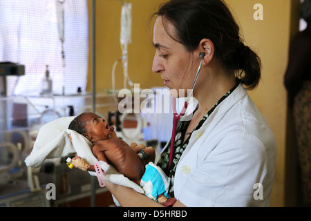 female german doctor examining newborn african babies in incubator. Hospital in Techiman, Ghana Stock Photo